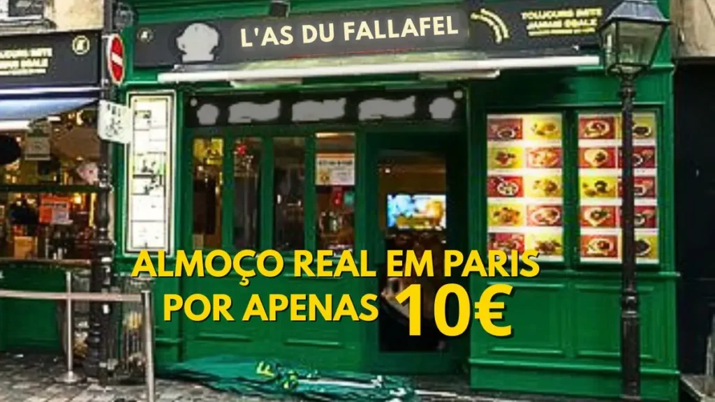 Exterior view of L'As du Fallafel in Paris, a green-fronted iconic eatery in Le Marais famous for its affordable falafel sandwiches, featuring a yellow text overlay stating "Real lunch in Paris for only €10".
