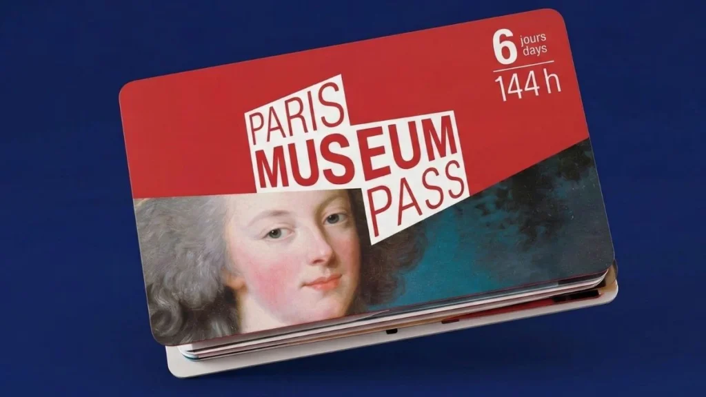 A close-up photograph of a laminated red and white 'Paris Museum Pass', featuring the large, stylized title 'PARIS MUSEUM PASS', a small validity marker for '6 jours days' and '144 h', and a detailed portrait section of a classical noblewoman with grey powdered hair. The pass is set against a solid deep navy blue background.