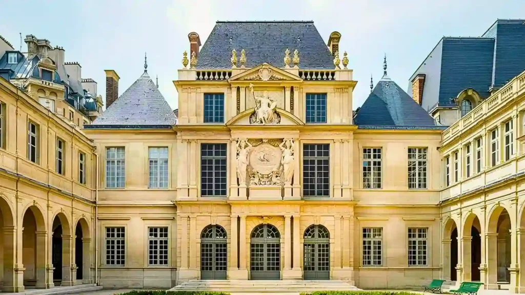 The stunning Renaissance architecture of the Carnavalet Museum's inner courtyard in Paris, featuring magnificent stone facades, elegant arches, and a beautifully peaceful atmosphere.